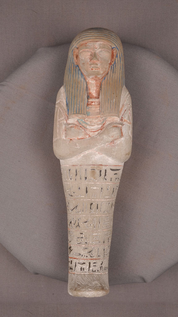 stone carving of a mummy with paint around the crevises