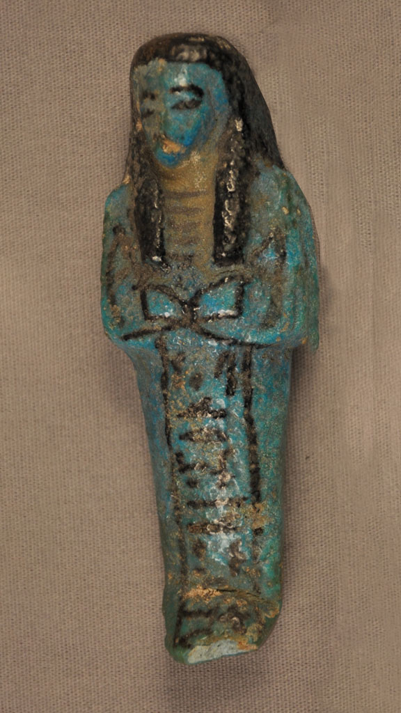 blue green stone carving of a mummy with black outlining